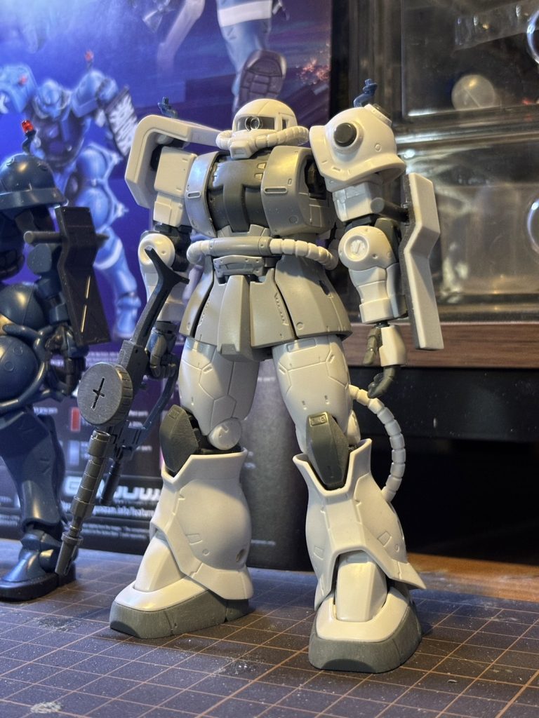 塗装直前です。通常のザクとの相違点はスクラッチも考えたんですが、（めんどくさかったので）部品請求で取り寄せたパーツを加工しました。真鍮線なんかも試したんですが、あの太さであの精密さで曲げるのが、ちょっと私には難しかったです……。どうしても緩やかになってしまって格好悪いので、おとなしくキットから拝借しました。右肩のシールドはジークアクス版をそのまま使おうかとも考えたのですが、左のシールドをシールが貼りやすいようにつるんとさせるつもりでしたので、合わせてつるんとした元のザクのものをぶった切って使いました。左肩スパイクは一段目？を残して切除、コトブキヤさんのリベットを貼り付けています。ペインティングモデルにマガジンつきのマシンガンは付属しないので他オリジンザクから。素立ちでもスッと持てるようにストックを薄く削りました。