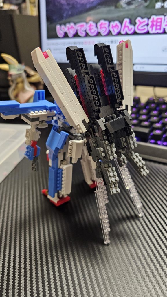 後ろから。バックパックの影響で自立しないので透明なレゴで支持させています。下部のスラスターのカバーとキャノンが可動します。