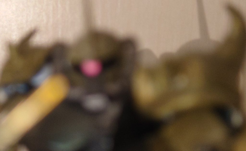 　「ふむ、相変わらずせっかちだな　だが話が早い　これを見てくれ」と一葉の写真を手渡す　「これは…緑ですが、ｼﾙｴｯﾄはグフですか」　「そうだ　今、基地で噂になっている密林の絶望、その正体だ　先日行方不明になった陸戦型ジムの機体が発見されてね　ほぼ全壊だが、頭部カメラのﾒﾓﾘｰが発見されてね　情報部で解析して、その画像だけがかろうじて割り出せた」　「私にこれをヤレ、と…」　「そう　君のｶﾞﾝﾀﾞﾑｺﾏﾝﾄﾞｰなら出来るだろ？」問いに少佐は立ち上がり、大佐に正対して敬礼　「承った！」　以来、一月　少佐はパトロールチームが行方を絶った地点をしらみつぶしに調べ、また自らをオトリにしていた　そしてある確信を抱いた少佐はこの3日間、集中的に同じ地点を巡っていた