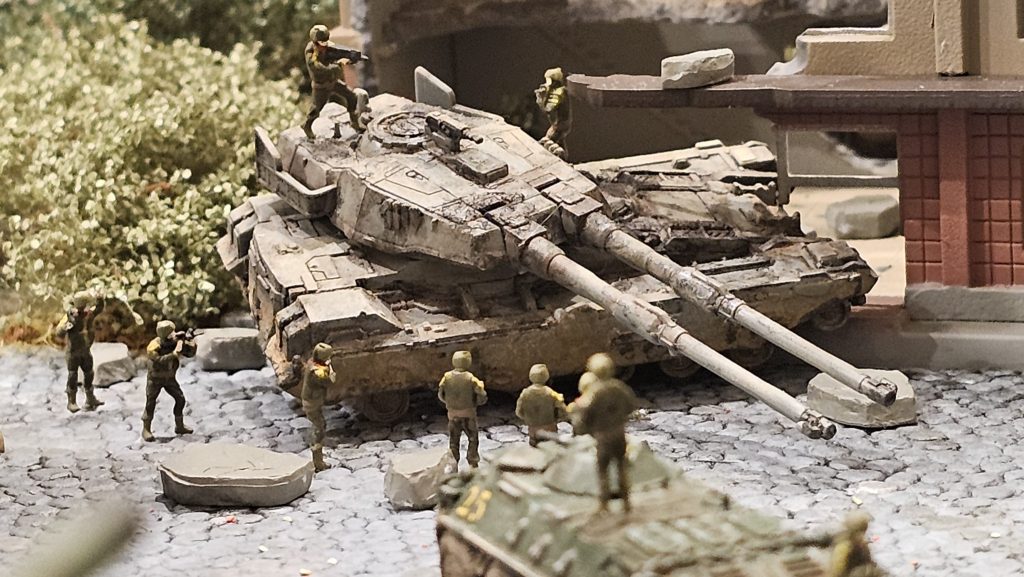 放棄された61式戦車を建物に当たる角度で配置。ジオン兵が内部の確認のため取り囲んでいます。