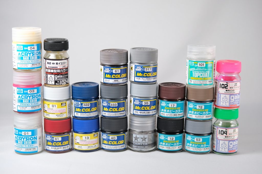 【使った色】白 UG01 MSホワイト淡グレー C35 明灰白色赤 C81 あずき色青 UG13 MSブルー( Z系)+C322 フタロシアニンブルー 6:1くらいかな黄色 G1024 西武線イエロー黒 C40 ジャーマングレー関節など C333 エクストラダークシーグレーバーニア C104 ガンクローム+C61 焼鉄色 1:1その他 C61焼鉄色 C315グレー G104蛍光グリーン G102蛍光ピンク アクリジョンベースカラー白・赤・黄色【スミ入れ】 ウェザリングカラー:マルチグレー マルチブラック 水性ホビーカラー: H53ニュートラルグレー H17ココアブラウン H72ダークアース H12ブラックトップコート GH101プレミアムトップコートUVカット(瓶タイプ )タミヤモデリングワックスエアブラシを導入したのが途中からだったので、白・黄色・グレーとライフルは筆塗りです。