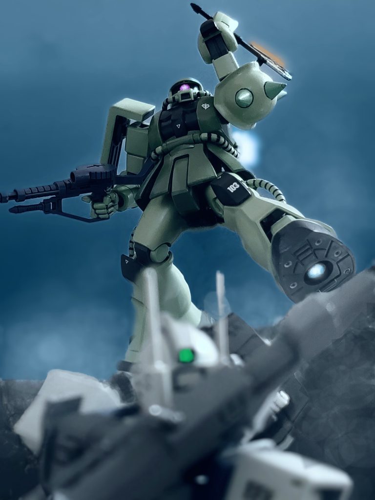 激しい戦闘の中、アニタ軍曹はセンサーと振動音を察知し声を張り上げる🔊⚡👩『バックス隊長‼️真上です💦』その声と同時にジムキャノンコクピットの警告アラームが上方に敵の接近を知らせる⚠️バックス中尉は機体を旋回しモニターを上方へと向ける⤴️と、そこには崖上から飛び込んできたザクが1機😱‼️ヒートホーク🪓を振りかざしながらバックス中尉のジムキャノンへ襲いかかってきた💦