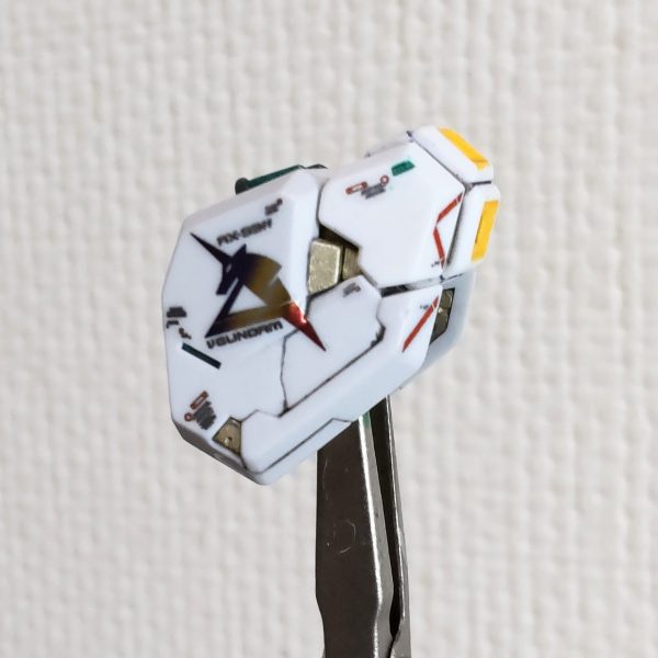ファンネルの塗装が終わってませんが、家で出来るデカール貼りを少ししました。このデカール、モノが新しいからか？適度な固さがあって貼りやすいです😄。νガンダムのデカールをνガンダムのマットで切り出す😄、何か運命を感じます😆。このマット、昔ガンプラを買った時の配布品で非売品なんですよね😁。私、基本は塗装しないので塗装用の持ち手をあまり持ってないんです😓。ファンネル、パーツ数が多く持ち手が足らず1度に塗装が出来ません、場所も移動しないといけないので無駄に時間がかかってます😓。（1枚目）