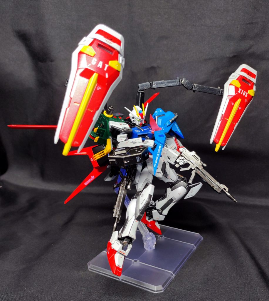 マイダスメッサー投擲！各所に追加された装備の影響により、出撃時の機体総重量が増加したことで機動性が低下しているが、各武装は弾切れと同時に順次パージすることでデットウェイト化を防ぐ仕様となっている。また、低下した機動力の補助として、脚部に外付けのブースターを増設している。ブースターも武装と同じく内部推進剤切れや破損などにより適宜パージされる。