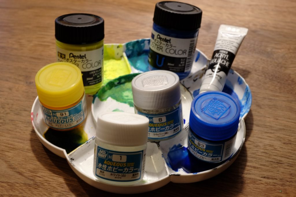 最後に今回使った塗料のメモサイコフレームは水性ホビーカラーホワイトの上にポスターカラーの蛍光色レモンとあおを基本にあおだとレモンに比べて光が弱いのでアクリルガッシュの蛍光ホワイトを少量混ぜて調整。グラスフェザーはパネルの部分を水性ホビーカラーのシルバーを下地にクリアイエローとクリアブルーでグラデーション。シルバーに遊びで蛍光ホワイトを少量入れたけどやらないほうが良かったかもしれない。仕上げにスミ入れをポスターカラーの蛍光色で行って半光沢のトップコートを吹いておしまい。以上ご覧いただきありがとうございます。