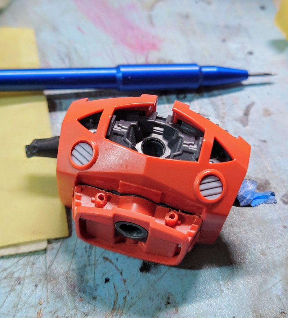 工作…発売時期の割にはパーツ割りも考えられているなぁと感心したんですが、脇腹の◎のモールドを跨ぐ合わせ目は目立つので処理しました。そのままだと顔(？)の外装も外せなくなってしまうので脇腹の部分をスジ彫り工具で彫り込んで分割しています。上側は塗り分けを考えて段落モールド処理にしてあります。