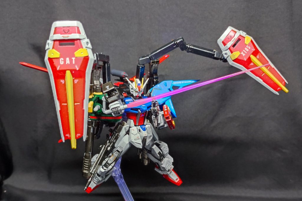 ビームガトリング・ライフルで牽制しつつ敵MSに接近戦を仕掛ける！ランチャー・ソードストライカーの主武装は取り回しとバッテリー消費の観点からオミットし、手数と攻撃手段の向上のため肩のサブウェポンのみ両方装備している。耐ビームシールドは工業用マニピュレータを流用した懸架アームにて接続し、追加兵装は各所に増設されたハードポイントにマウントされる。また、マニピュレータの可動域確保のため、本来エールに搭載されていたビームサーベルは両肩のストライカーへと設置場所を変更している。耐ビームシールドを懸架するマニピュレータは、ムウがパイロットに決まったことにより、キラの協力の元メビウスゼロのガンバレルに類似した制御を取り入れたことで、ある程度の負担を軽減しつつ柔軟な操作を可能とした。 