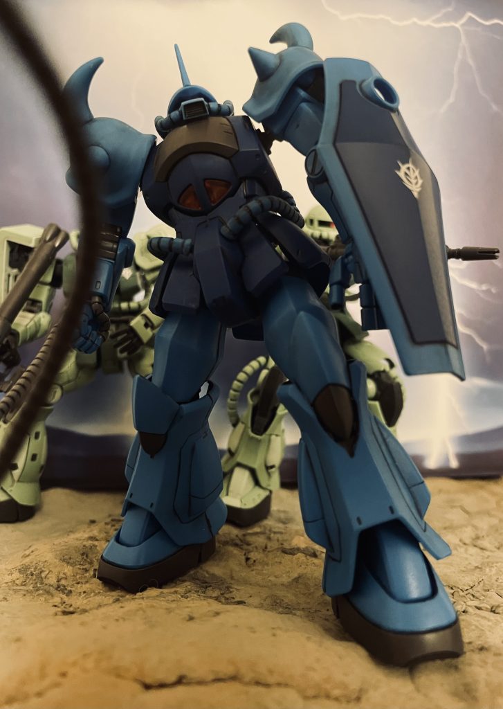 V作戦が地上で対峙した強敵、グフの登場シーンをイメージしています。第12話「ジオンの脅威」にて雷鳴とともに現れるジオンの新型モビルスーツに戦慄するV作戦戦士達。MGグフ version 2.0のボックスアートはこのシーンをベースに描かれているものと思料。