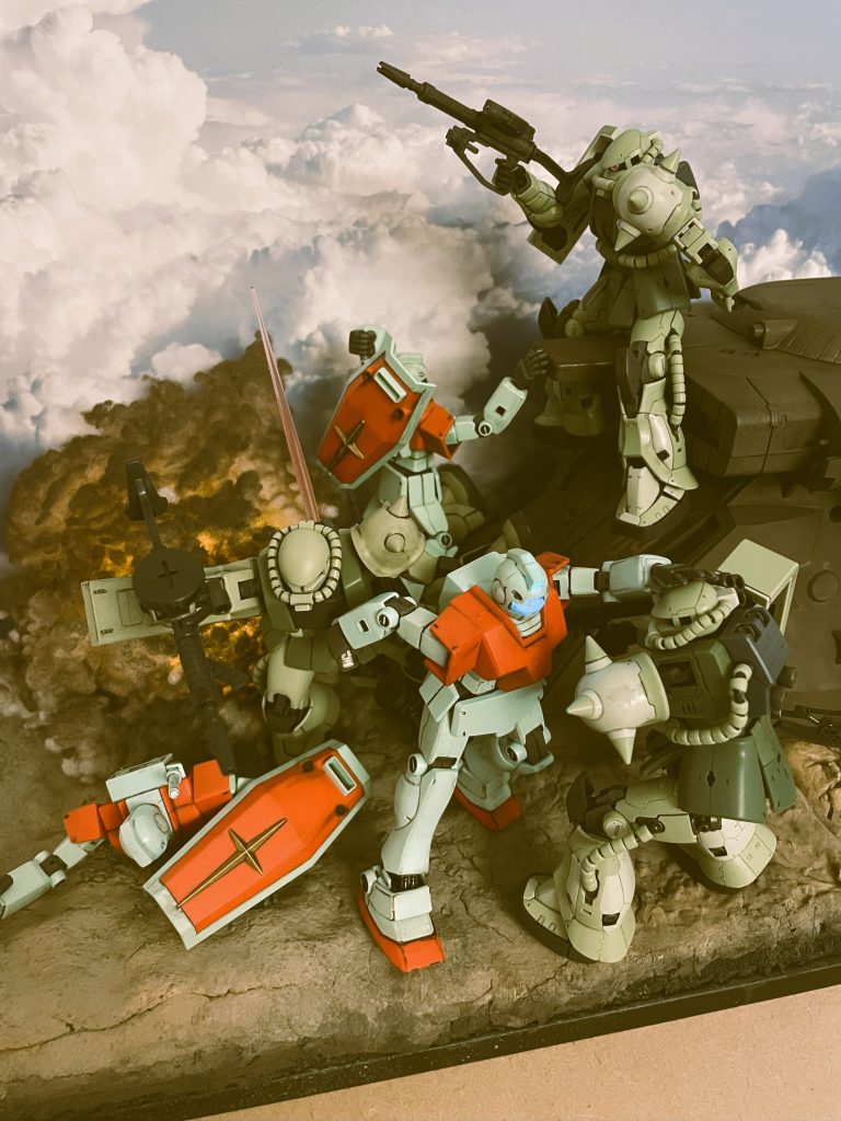 後ろ手にサーベルで突きつつ前方のザクの頭を押さえつけるジムです。