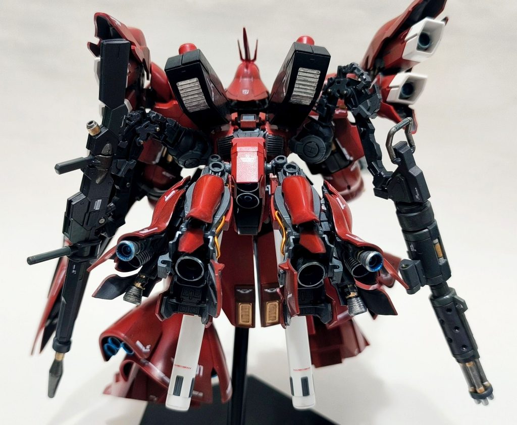 背面。シナンジュのバックパックを基本とし、ジャンクパーツによる肉付け+ファンネルの接続に加え、サブアームを追加してサブウェポンを搭載できるようにしています。サブウェポンは水性の魔女のデミバーディング用オプションパーツから、ロングビームライフルとガドリング(ビームガドリングに脳内補正)をマウントできるようにしています。時空を超えたミキシングはやや主義に反しますが、汎用武装ということで…。メインスラスターは、シナンジュの脚部パーツ、ひざ下部分です。足首から下をバーニアに変更し、いくらか外装を外してむき出しの部分を作ることで、スラスターっぽく仕上がりました。