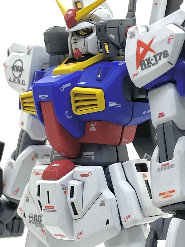 旧HGUCのガンダムMk-IIは合わせ目が大変多く、全塗装する際には面倒なので今回は後ハメをする事にしました。箇所は頭、肩、膝関節、脛のバーニア、足首のフレーム、アンクルガードでⅭ字加工したり、ピンを切って取付の際に接着したりしてますが・・・・脛の外側にある黄色いバーニアは後ハメにするにはかなりキツいので相当削っていますが擦り合わせは必須でした。今回は時間短縮の為に白とグレーはガイアのサーフェイサーのままですが綺麗な塗膜で良かったです・・・動きますと流石に少しは剥がれますが(汗)。アムロ機のイメージカラーですから鮮やかなトリコロールにしたかったので腹部はマスキングして赤を塗装、後はガンダムと同じように青を塗装しνガンダムと同じマークのデカールを貼りました。設定としてはカミーユからマークⅡを譲られたアムロが宇宙に上がり、アーガマに配属されるというイメージでアーガマのマーキングも入れています。