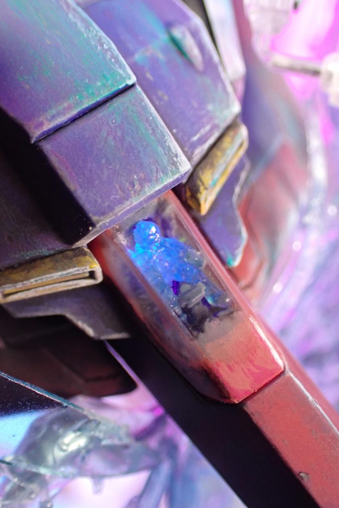 コックピット外装を透明素材に起き換えて、透明廃ランナーを溶かして作った約1/144カミーユを座らせて背中側から電飾を当てています。