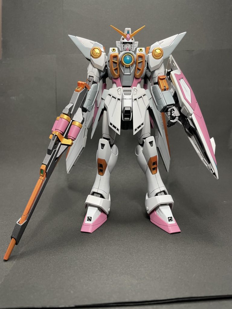 全身正面今回は胸部回りを中心とするネイビー部分のパーツを全てグレーに、アンテナやウイングのイエロー部分とライフルやスネ部分の一部をゴールドに、レッドパーツはセイラマスオカラーで塗装し、いわゆるガンダムトリコロールとは一線を画した見た目にしてみました。バスターライフルも後述しますが大きく配色を変えています。 一応今回の配色コンセプトは「ヒイロが自爆し、破壊されたウイングガンダムをゼクスが修復した際、機体構造のオリジナル再現に注力した結果、機体色は持ちうる最低限度の塗料や、製造過程で化学反応を起こした合金そのものの配色を反映したもの」という脳内設定です。 ゼクスが修復したウイングガンダムは、言わばウイングガンダムMk.IIともとれる機体。こんな配色にしたらヒイロは受け取りを拒否しちゃうかも…なんて思ったりもしましたが、簡単に自爆もすれば海中に放棄もしちゃうような薄情なパイロットなので、「色などどうでもいい」とか言いながらすんなりと乗るのも想像できて複雑な気持ちで塗装しましたw