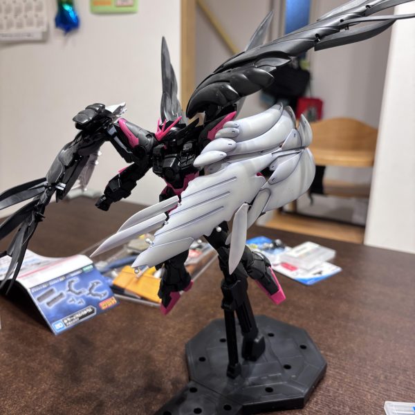 HJ誌で見たメタルビルドの「スノーホワイトプレリュード」がとてもかっこいいなと思い、セラフィムユニットを自作しようかなと思いましたが、自分の技量を考え断念しました😅作例よく見かけるのですがプレバンでパーツ販売してるんですかね？プレバンの検索上手にできないので知っている人いたら教えて欲しいです…さて、できることをやっていこうと、旧ゼロカスタムから羽を頂き、ブキヤの「フレキシブルアームB」を使い簡単接続です。昨年作成した「ライジングZフリーダム」の残り物です。ポリキャップ接続なので保持力ガバガバなのが次の課題です。 （3枚目）