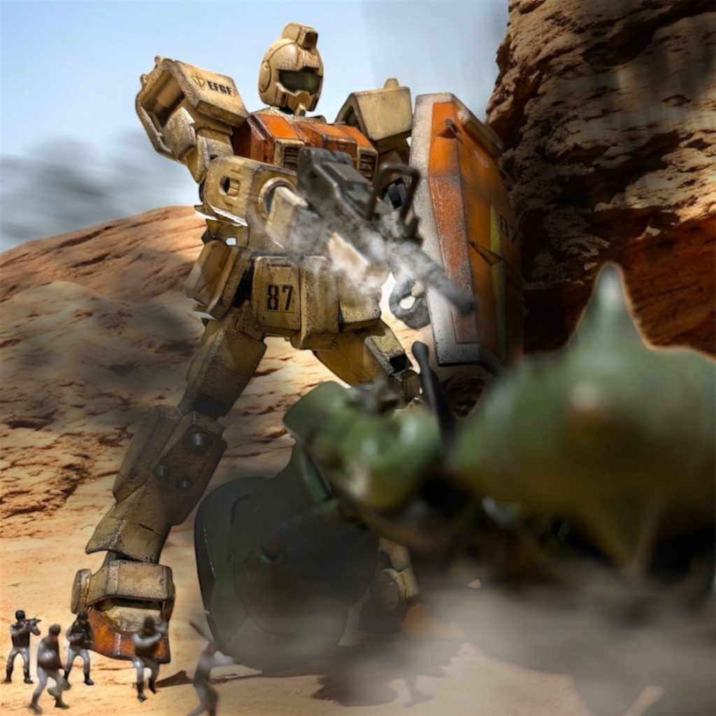 『あとは任せろ!』なんとかかいくぐってきた1機は、イギーが飛び出して、いつも通りの体当たりをかます。青天井のところに100mmマシンガンを叩き込まれ、沈黙した機体に歩兵隊が群がった。(開けた平野なら、戦車とタンクの滑腔砲が有効に機能するはずです。主力の戦車隊を指揮しているエイガー少尉からもお墨付きですよ。) ヘントは、昨日、戦隊の戦車隊長を務めるジョージ・フォッカー准尉が、力強く話した言葉を思い出していた。前方に開けた荒野では、あちこちで十字砲火を浴びたジオンのMSが火を吹いて倒れるのが見えた。『我が軍の61式戦車もなかなかやるじゃないか。』「まあ、物量の勝利だろう。」イギーの感嘆の声にも、ヘントは冷静に返す。『いいや、気合の違いだ。故郷を焼かれたアースノイドの、怒りの炎を思い知ってもらうさ。』そうだった。自分と違い、イギーは地球生まれだ。彼の故郷は、直撃こそ受けていないものの、大戦緒戦のコロニー落としの影響で壊滅的な被害を受けている。妻子は難を逃れたものの、両親や祖父母を亡くしているため、ジオンへの恨みが深い。イギーの言う通り、連邦軍にはコロニー落としに対する怒りが強い兵士が多い。対するジオンの兵は、管理された清潔なコロニー内とは違う、過酷な地球の環境に適応できず、厭戦気分が蔓延しつつあるとも聞く。