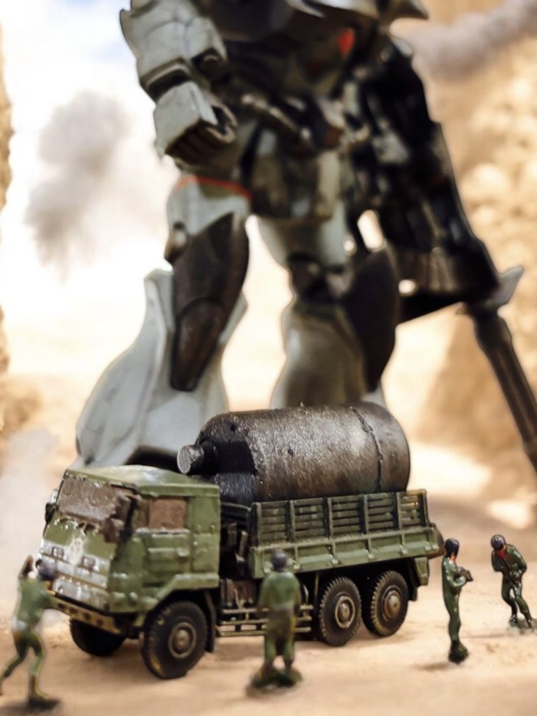 『さすがです。連邦のMSもどきなど、大尉の敵ではありませんな。』補給用のトラックが機体の足元に近づく。ガトリングの弾薬を受け取りながら、歩兵隊のバリー軍曹の声を通信機ごしに聞く。この局面でも声色が明るいのは、アーサーの力を信じ切っているからだろう。 確かに、戦車の1輌1輌、タンク型MSの1機1機は、格闘戦の相手としては大したことはない。しかし、物量が違いすぎる。遮蔽物を利用して、身を隠すなり、横の機動を駆使して戦える戦場ならば、MSに大きな分がある。しかし、開けた荒野では直線的な機動になりがちだ。自由度の高い立体的な戦術的機動を取れることがMSの利点ではあるが、宇宙や市街地と違いただっ広い平地ではその強みが生きない。平地でああも激しい砲撃を浴びせられれば、MSも戦車も陸上艦も、手も足も出ないことにさして変わりない。