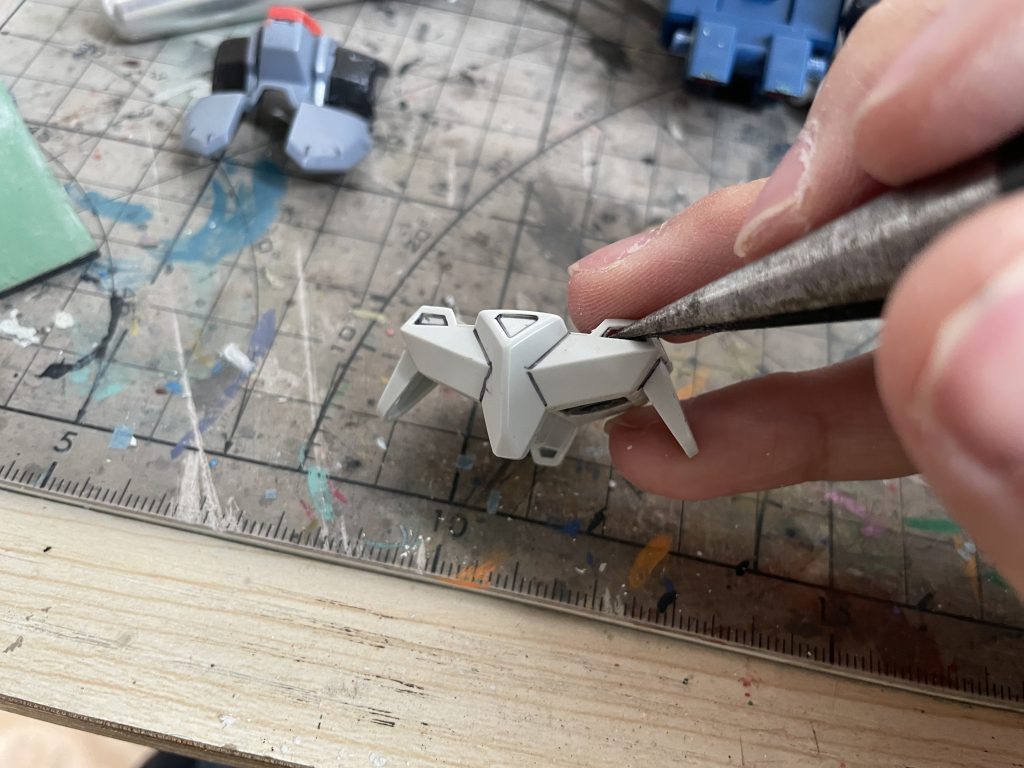 後部スカートアーマー増設工程アサルトシュラウド装備時は前後スカートアーマーが追加されるが、SDキットには後部スカートアーマーパーツが未付属。  今回の制作は「デュエルガンダム」と「デュエルガンダムアサルトシュラウド」にキットを分割使用したため、余剰アサルトシュラウドパーツを流用し:  1. 本体後腰部に接合用の穴を開け