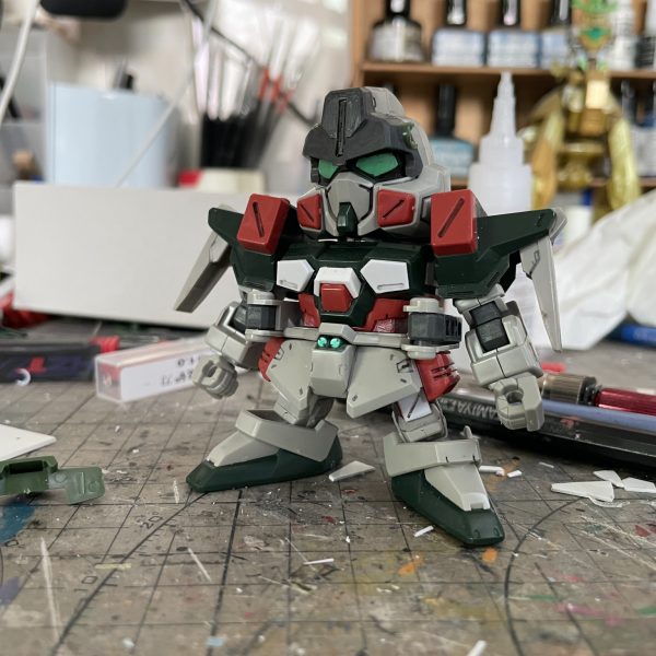 一年前、SDヴェルデバスターガンダムをベースにSDバスターガンダムへ改造した際の工程記録を公開します。第二弾は「胴体」と「バックパック」の改造工程です。  【胴体改造】1. プラ板を二重積層し胸部装甲の形状を再現 2. 元キットの胴体赤パーツからコクピット部のみを残して切削3. 切削パーツにプラ板を貼り付け、胴体との組み合わせを調整  【バックパック改造】バスターガンダム特有の可動アームについて：  腰の可動制限＆SDスケール再現難のため、アーム上部形状のみをバックパックに直接固定、武装接続部に磁石を埋め込み、着脱式の武装を実現「胴体とバックパックの換装完了！可動制限を回避しつつ特徴を再現」（5枚目）