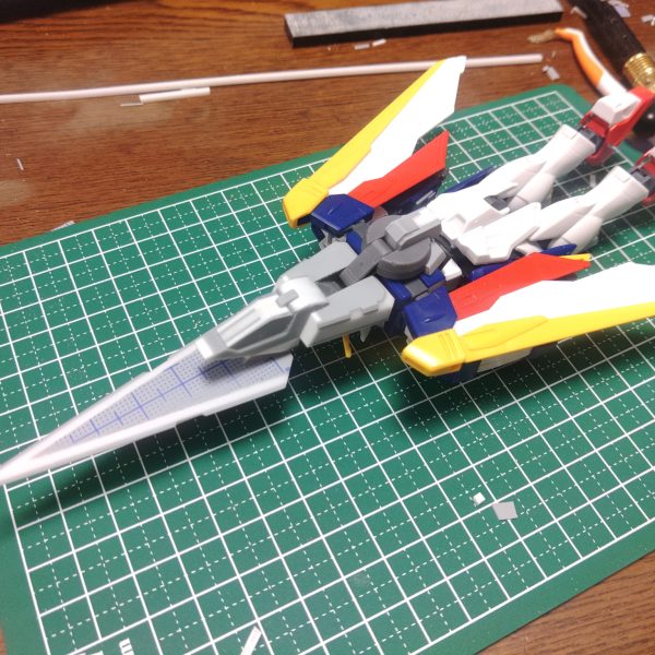 ウイングゼロとダブルオーガンダムを合わせたWOガンダムってコラを見てふと「素ウイングガンダムを太陽炉搭載機にしたらどうなるか」と思い立って製作を開始しました。イメージとしてはビルドダイバーズ世界観で宇宙世紀機に太陽炉を組み合わせたGP羅刹に憧れたビルダーが作った的な感じで。変形機構はキュリオス系統を参考にしてシールドを廃止、武装はダブルオーに習ってバスターライフルからバスターソードへ。 なるべく新造部分はプラ板フルスクラッチメインでやっているので進みが遅く現在進捗六割って感じですが、気長に作っていこうと思います。（5枚目）