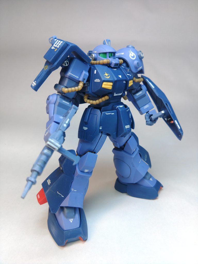 成型色仕上げの関係上、改造するパーツは同色のものが必要なので、ランナータグ以外はキットを幅詰めした時などに出る端材を活用しています。改造点は以外です↓ 右肩のショートシールド右肩シールドを短縮して、切り取った部分にランナータグで蓋をしてから、増加装甲として盾に貼り付けています。 ビームスプレーガンザクマシンガン改を解体して、パーツを組み換え再接着してそれっぽく仕上げています。 頭部前回のハイザック ティターンズ仕様と同様の改造をしていますが、モノアイの縦の幅詰めはバイザーが見えにくくなるためにあえて狭くしませんでした。バイザーは顔の幅を詰めて入らなくなっているので、バイザーパーツも一回り削り込んでいます。耳は切り離したスパイクアーマーのスパイクを貼り付けてから整形、アンテナは伸ばしランナーと、アンテナ基部はランナーをリューターに噛ませて回転させ、ロクロの要領でデザインナイフでモールドをいれたものを組み合わせています。リューターの回転数を低くくすると成功率が高いです。 その他手持ちシールドの持ち手はランナーから製作胸部は3分割して肩がハの字になるように修正、胸部カメラもランナータグで新造バックパックの取り付け穴を下に空け直して取り付けた際に上に着くように修正、バックパックのセンサーも短縮脚部の赤いスタビライザーも短縮胸部とスネ、スパイクアーマー、足首ジム系の角張を意識して、プラ厚ギリギリまでC面を調整して、平らに且つ面取りが広くなるように削る