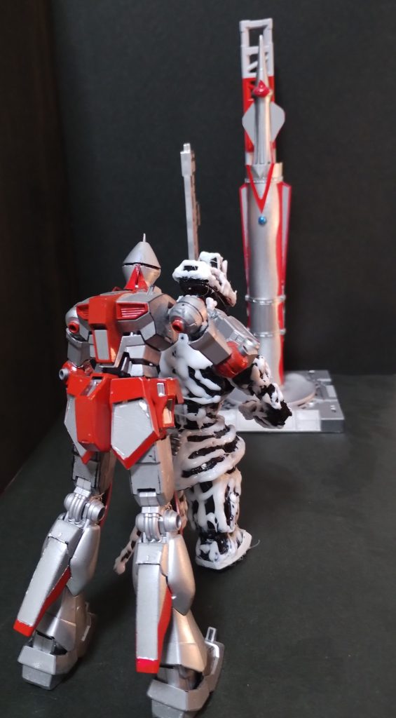 嫌がるウミモンクを無理やりロケットに連れていく。モビルスーツの戦闘では前代未聞の光景だ。(ロケットは100均の電柱とゴルフのティーで製作しました)