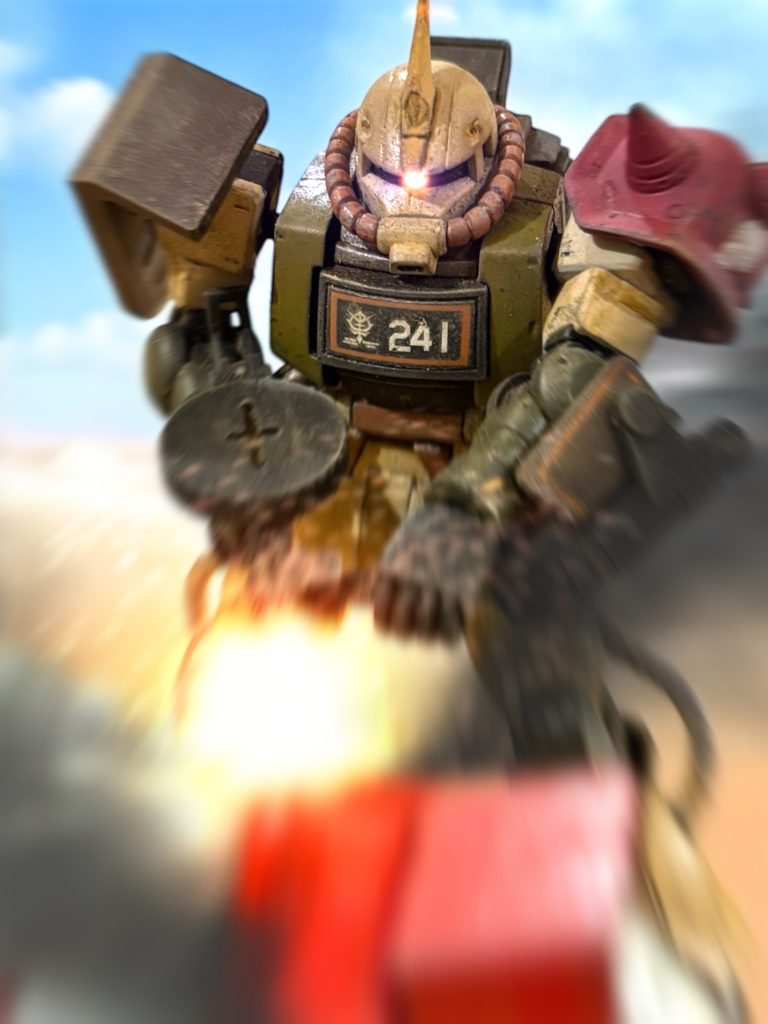 　あっという間に敵機に詰め寄ると、突出している機体に各個で組み付いた。　それぞれに至近弾を叩き込むと、思っていたより簡単に、敵機の装甲は火を吹いた。「なんだ！？ガンダムにザクのマシンガンは効かないと聞いていたはずだぞ！？」攻撃を仕掛けたハリソンが、むしろ動揺した。突出していた敵の３機は撃破できた。『少佐！』グレーのグフのパイロット、アーサー・クレイグ大尉の声に、直感的にハリソンは機体を後退させる。ピンクの火線が機体をかすめた。「ビームか、面白い！」　ビーム兵器を装備した機体が２機。あれに捕まれば、一撃であの世行きだ。　銃弾をまき散らしながら、機体を思い切り後退させる。ここでも、機体の増設されたバーニアが役に立つ。まるで宇宙空間での戦闘のように、ハリソンの機体は地表をすいすいと滑った。