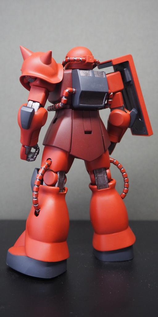 当時ジオン軍の主力機は核バズーカ使用のため耐核装備が施されたMS-06C《ザクⅡ初期型》であったが、ルウムでは対象コロニーを防衛するという作戦目的上、主戦場において核バズーカの使用は制限されていた。そんな中、宇宙攻撃軍第6機動大隊第4小隊隊長シャア・アズナブル中尉は、赤いザクを駆り単騎5隻もの戦艦を連続撃沈するという大殊勲を上げる。この時の搭乗機は、塗装未完了の下地状態で配備されていた予備機であり、制御系のリミッター設定はおろか放射線遮蔽材の注入さえ済んでいなかったと伝わる。地球圏全体に「赤い彗星」の二つ名を鳴り響かせることになる所謂「シャアの五艘飛び」であるが、一説によると使用機体はMS-06Cに偽装された高性能試作機であったともいわれる。総帥府ペーネミュンデ機関は戦争の長期化を見越し、プロバガンダのため”戦争の英雄”を必要としており、その候補者たるエースパイロットには事前に特別な機体が手配されていたという。次期主力モデルMS-06F《量産型ザク》ではモビルスーツ本来の特長である機動性能を最大限に生かすため、耐核装備を撤廃し徹底した軽量化設計が施されていたが、更に上位機種としてYMS-06S《指揮官用ザク》が存在した。宇宙空間でのモビルスーツは一定条件内で制動可能な最高速が、その機体にとっての戦闘速度となる。つまり耐核装備による高重量でAMBAC効率にも劣るため速度を低く抑えざるをえないザクⅡ初期型に対し、それらの問題点が解決された指揮官用ザクであれば、パイロットの技量次第では３倍の速さでの戦闘も現実に可能であったという。当時まだエースパイロットや指揮官機のパーソナルカラーによる個別塗装は制度化されていなかったため、機体色には戦場で目立ち、かつ味方に不自然さを感じさせにくい防錆下地塗料の色彩に擬したものが選択されたのだとされる。目撃情報を綜合するとルウム戦役時、同時に複数の”赤いザク”が存在していた事を示唆しているが、終戦時の文書散逸により裏付けとなる史料は現存しない。