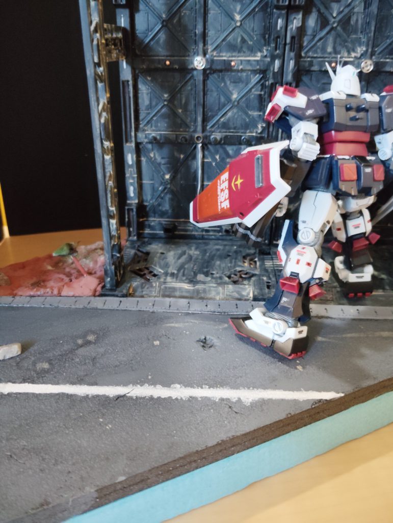 グレーで塗りたくったあとに白の中央線を塗る。穴をあけたり、ヒビをデザインナイフで作ったり