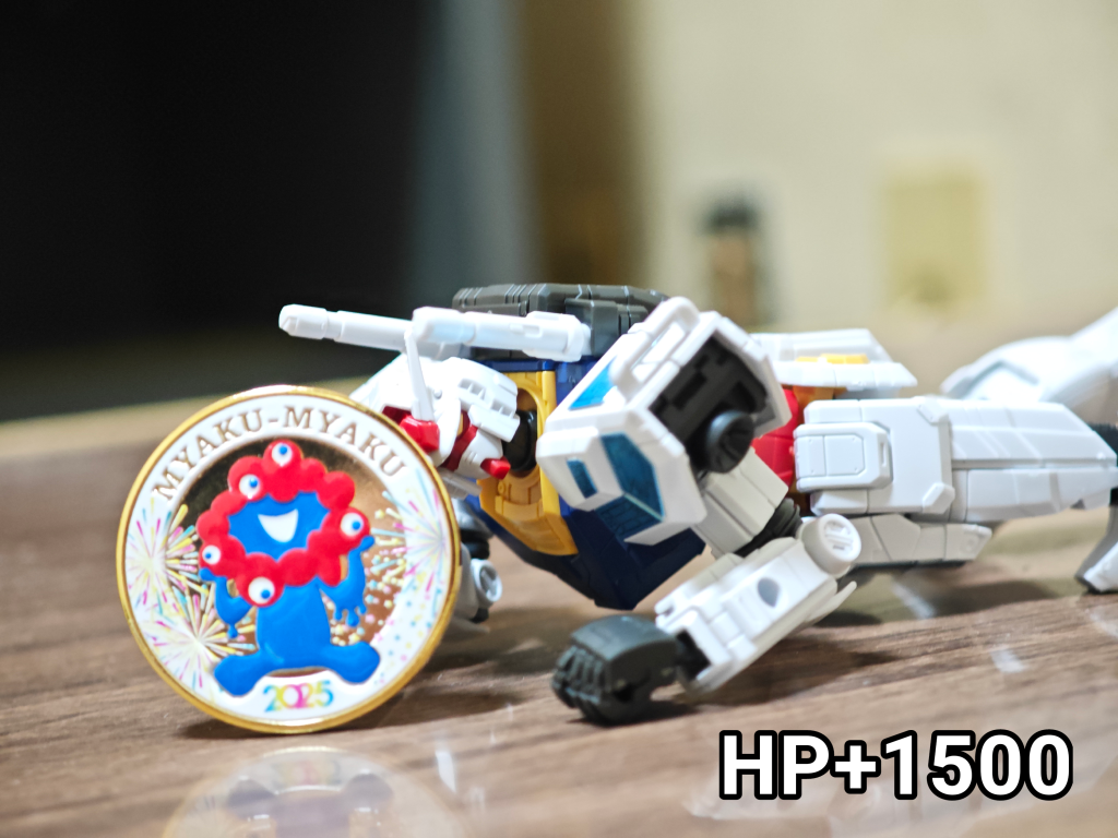 万博2025、最後は「ミャクミャクコイン」だ!ちなみにコインではあるけど実物はキーホルダー用の枠にセットされた状態で販売されてます。よく観光スポットとかで自動販売機で売ってる記念メダルと全くおなじ仕様の商品でしたね、名入れは無料でやってくれるようでしたね。