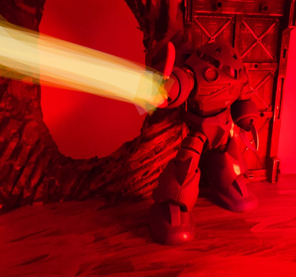 非常灯に照らされる中、ジオン軍の水陸両用重MSズゴックのメガ粒子砲から放たれた太い光条が、2機がいた通路を貫いた