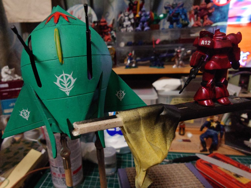 ゲルググの塗装に悩みまして…割り箸に両面テープ付けてゲルググを固定　黒サフしてメタリックレッドで塗装　デティールは壊滅的なので、デカールで誤魔化しました　肩にシャアの「A12」