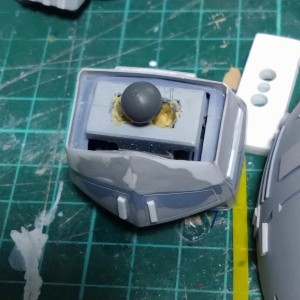 ジオングの続きです。少しずつディティール追加をやってましたが、ここにきて急に腰の前後可動に左右の可動を追加してはどうかと考えまして、以前悩みながら形にした腰のパーツ部分にボールジョイントを入れるのを思いつきました。しかし全体的にまとまって来た今からの穴開け、削りは少々勇気が入りますが、やらない後悔よりはやって失敗しても何とかしようと思い軸を切断、穴開け開始。あーもう戻れない。とりあえずパテで固定。ある程度の仮合わせはしましたがボールジョイントが結構硬いので完全硬化を待っての確認になります。3枚目は加工前の軸延長してプラ板重ねてスペーサーにしていた写真です。  （2枚目）