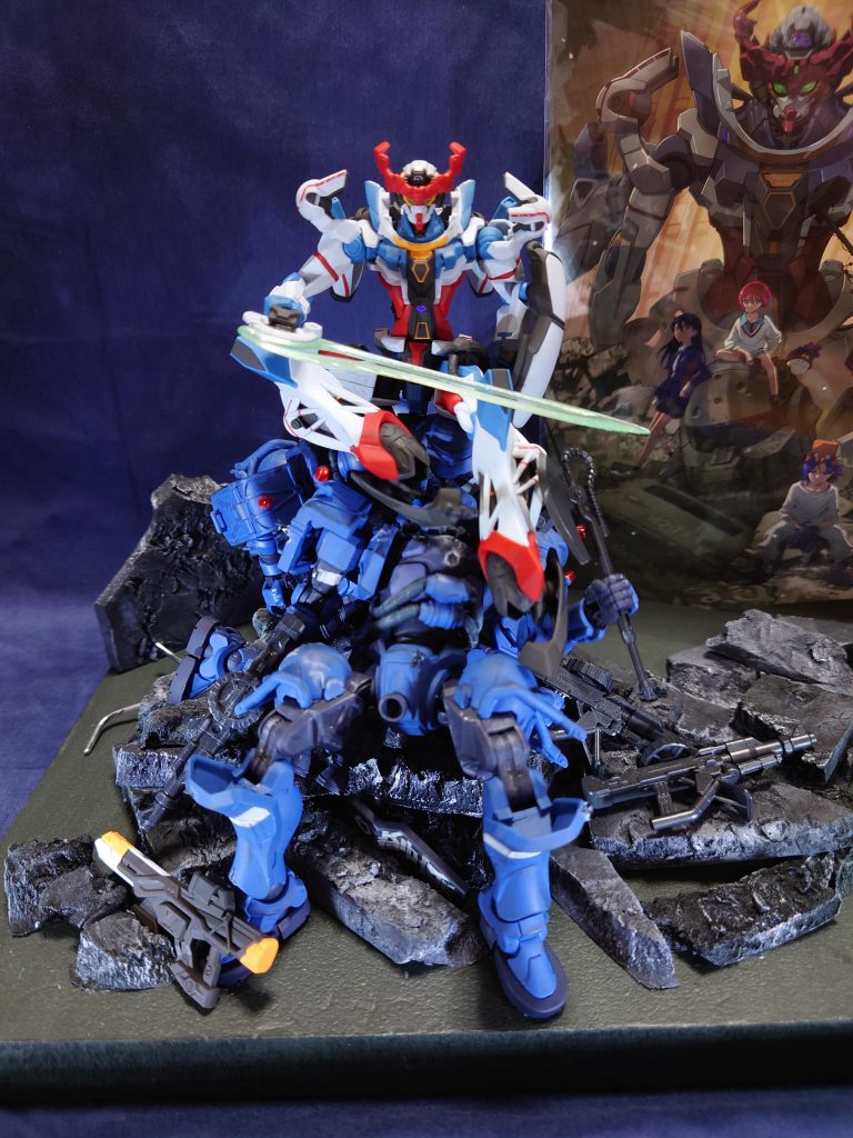 キービジュアルにてザクの頭部に座るマチュをGQuuuuuuXで表現しています。土台部分には軍警ザクを3体を使用しています。