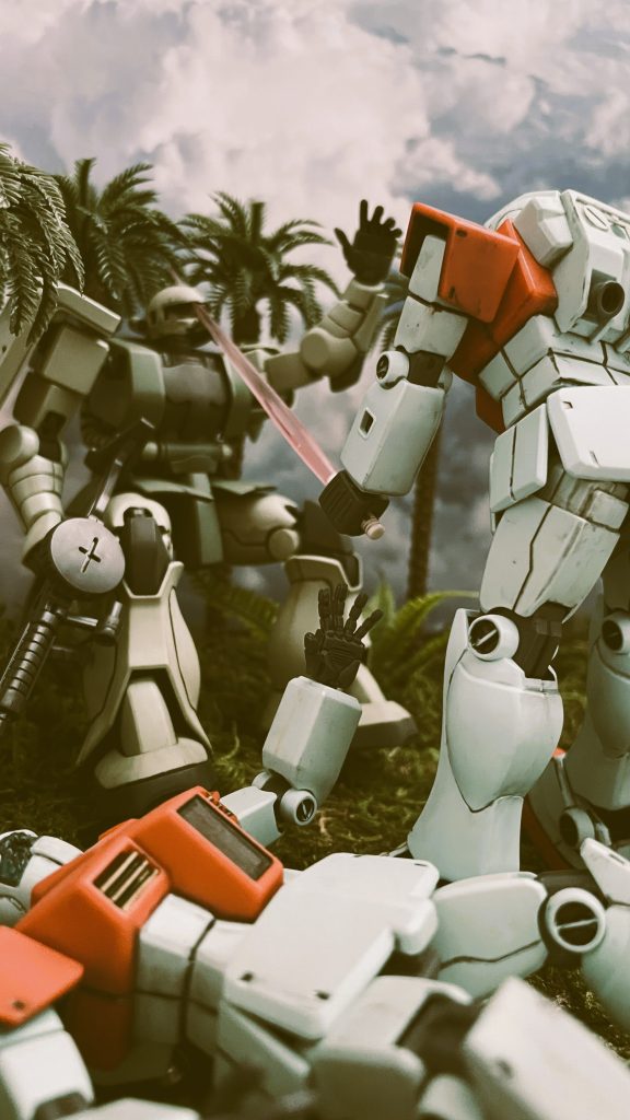 ジムに頭部を割られるナウマンのザクです。ビームサーベルでの攻撃を表現するためHGザクの頭部へ超音波カッターで切り込みを入れています。手前のジムのカメラへ2.5mmピンバイスで穴をあけ着弾のダメージを表現しています。