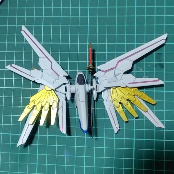 まずプラウドディフェンダーが完成しました。機首のグレー部は本来シールを貼る場所ですが、シールはそのうち剥がれることが多いので塗装にしました。塗装は刀の鍔以外は全てガンダムマーカーです。イエローゴールドはエアブラシシステムで。グレーとブルーはペンで直接塗ったらムラムラだったので、筆塗りに変更しました。刀――フツノミタマは白の１パーツ成形だったので塗り分け。鍔の部分は前にDAISOで買っていたペイントマーカーを筆塗りで。110円といえどもさすがペンテル、いい発色です。ただしもともと塗装用ではないので、インクを出してもすぐ乾いてしまいます。（2枚目）