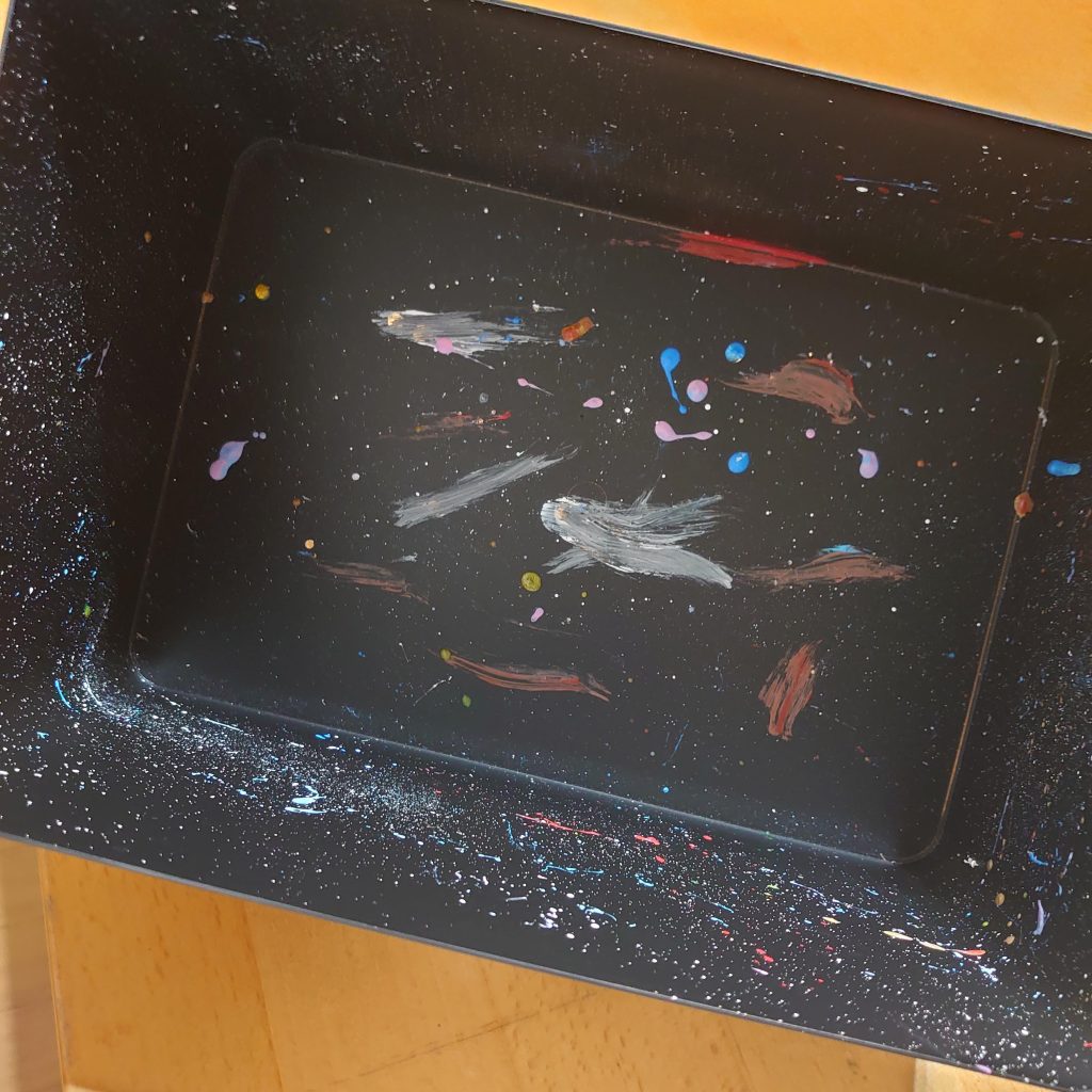 100均であった蓋つきのクリアボックスに黒のサーフェーサーを吹きその上から　白、青、赤・・・と歯ブラシで飛ばして宇宙空間を再現してみました