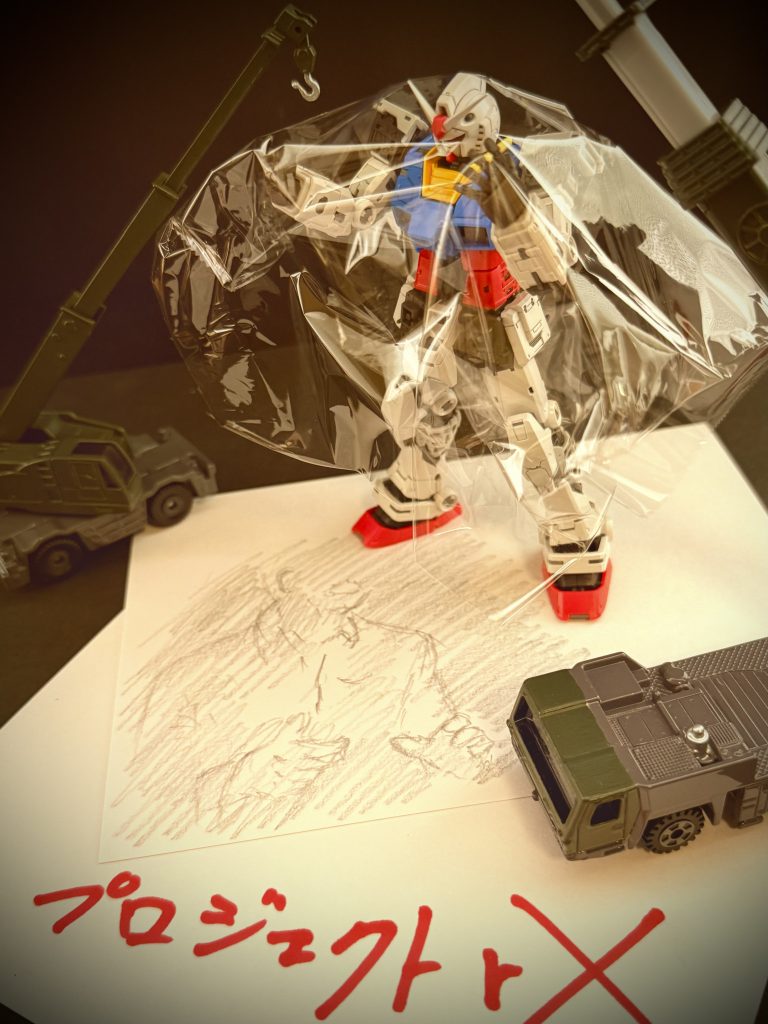 ※画像は再現映像 果たして、股間部に耐熱フィルムの収められたカートリッジケースを内蔵しRX-78は完成した。 MS技術試験場の敷地に立つ、八割ほどの外装を身に付けた18メートルの巨人、RX-78を見上げ、男達は歓声を上げる。これから、大気圏突入用耐熱フィルムの展開試験が行われるのだ。その場にいる誰もが、試験の成功を願った。 …静まり返る試験場に、試験開始の合図が鳴る。誰もが固唾を飲んで見守る中、ゆっくりとRX-78の腕が動く。股間部のカバーが開き、かるいガスの噴射音と共に吐き出される耐熱フィルムを、RX-78の太く、力強い指が捉える。…しなやかに動くRX-78の腕は、そのまま、展開したフィルムを機体を覆うように、頭から被る。 …だが、その場にいた全員が、息を殺し、見上げる中、それは起こった…。