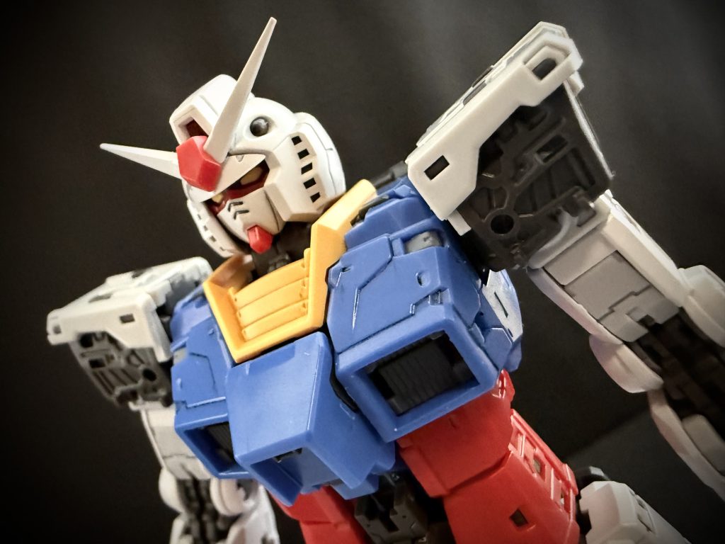 「破れた」のだ。 薄く軽量な耐熱フィルムではあるが、18メートルもの機体を覆うほどとなると、やはり、それなりの重さになるのである。そのフィルムは、RX-78のデザイン上最大の特徴である、頭部に装着された「ツノ」。ブレードアンテナによって、破かれたのだ。 鋭利に尖ったブレードアンテナの先端が、薄く軽量とはいえ、それなりの質量を持ってしまった耐熱フィルムを破ったのだ。 その場を支配する重い沈黙。 このような結果になることを、誰も想像しなかったのだろうか。いや、気付いていた者もいただろう。しかし、言えなかったのだ。時制は早急にこのMSの、V作戦の完成を望んでいた為である。 …やがて、沈黙がざわめきへと変わっていく。周りから聞こえてくる、ため息、悲観の声、または嘲り。天を仰ぐ者、頭を抱え込みしゃがみ込んでしまう者。だが、その中にあって一人、たった一人だけ、その惨状から目を離さず、前を向いて、毅然と立ち続ける男がいた。男はゆっくりと周囲を見渡すと、静かに、それでいてよく通る声で言う。「皆さん、大丈夫です。…方法はあります。」 もう完成しているのです。男は言う。耐熱フィルムも、このRX-78も。男が静かに、それでいて力強く言った言葉に、周りの人達が、目を丸くして聞いている。男は言う。「方法は…あるんです」 …プロジェクトアールエックス