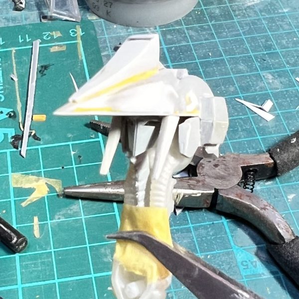 先週投稿したHG百式の進展状況になります。画像1、2枚目　EGνのヘルメットを縦に割って貼り付けました。BB初代大将軍の部品に永野テイストな物があったのでこれは首に使いました。画像3枚目　前の方のツノは本物は複雑な形をしてますが、私に再現は無理なのでプラ板で簡単に作りました😅画像4枚目　虫ピンをクリアレッドで塗った物です。フェイスパーツの裏は伽藍堂なのでこれを仕込んで瞳に見立てます。  （1枚目）
