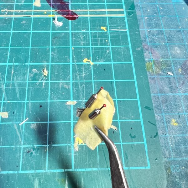 先週投稿したHG百式の進展状況になります。画像1、2枚目　EGνのヘルメットを縦に割って貼り付けました。BB初代大将軍の部品に永野テイストな物があったのでこれは首に使いました。画像3枚目　前の方のツノは本物は複雑な形をしてますが、私に再現は無理なのでプラ板で簡単に作りました😅画像4枚目　虫ピンをクリアレッドで塗った物です。フェイスパーツの裏は伽藍堂なのでこれを仕込んで瞳に見立てます。  （4枚目）