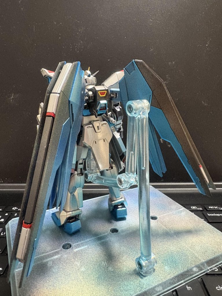 バックパックの赤黄の部分はシールです。色分け出来る技術がありませんでした。さらにウイングユニットにはコスモブルーのあと光の翼ホロブルーを軽く吹いて、光の翼がブワァァっと出てるようにして見ました。台座も同じように塗装してます。それとスラスターにもコスモブルーと光の翼ホロブルーを軽く吹いて、青い炎が出てるようにしてみました。