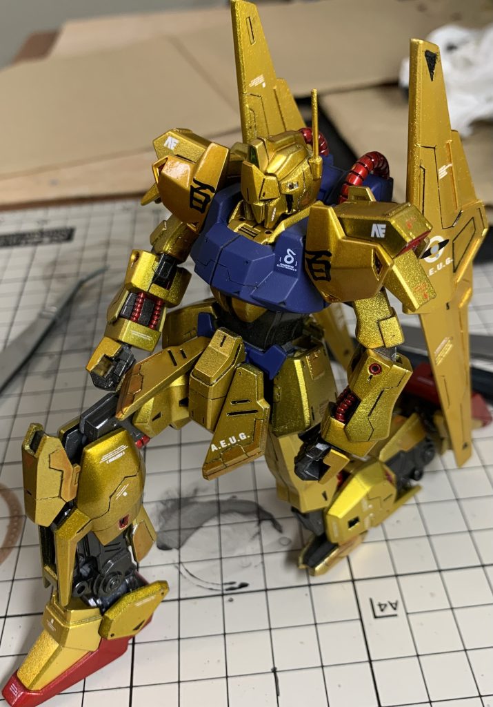 塗装に関しては、サーフェイサーで下地塗装→ゴールドで塗装→クリヤーイエロー、クリヤーオレンジでキャンディ塗装→バーニアや内部フレームをメタリック塗装→デカール貼り→トップコートで塗装(光沢、つや消し)→コンパウンドでパーツ表面の研磨→メタルパーツ、ラピーテープ、uvレジンの順で行いました。