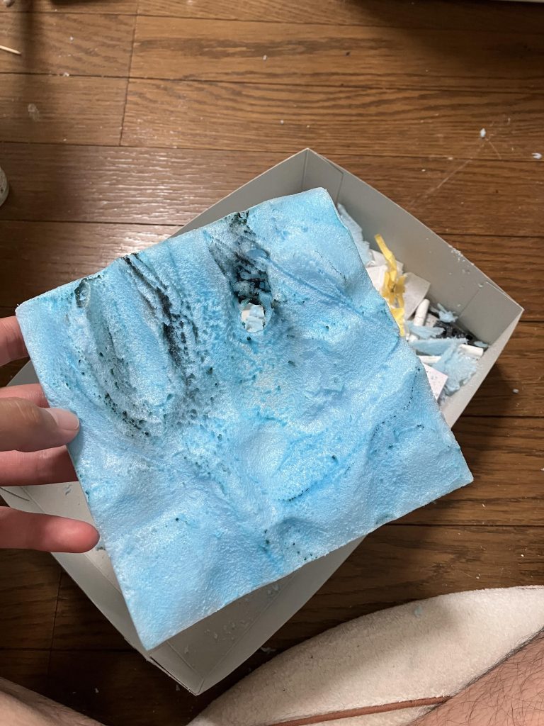 ③砂漠の作成ガンダムとグフを設置直前の砂漠の写真を撮りたかったんですけど取り忘れてました😭上の画像は発砲スチレンを砂漠にみえるようにカットし、丸みを出す為にライターで炙った際の作成途中の画像になりますここから石膏を盛り付け、リアルサンドをふりかけてジオラマの完成になります！砂漠のジオラマは砂漠の砂が山になってる部分を作るのが難しいですね🤨