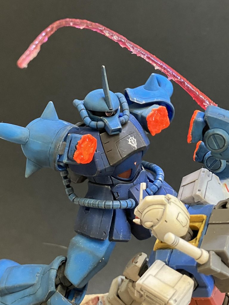 ②グフの切断された腕こちらは高温のビームで切られた事を表現する為、ハイパーカットソーで腕部をカットした後、はんだごてを当て、ドロドロに溶かし、十分に冷ましてからよりドロドロに見えるようボンドを塗布し、その上からガイアノーツのクリアーオレンジで着色をし、切断面が超高温であるという事を表現しました！