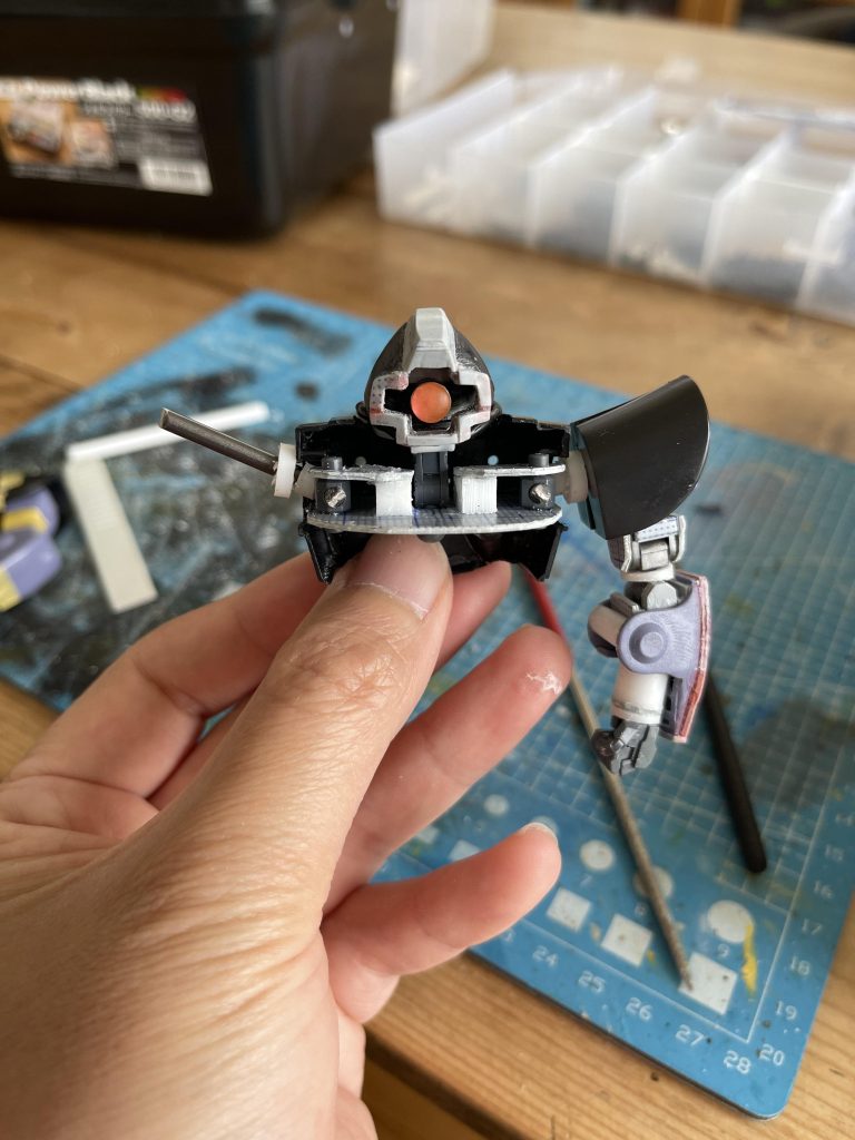 頭部はトサカ等をカサ増しし、モノアイ部分をクリアパーツに置き換えました。胴には腕部の引き出し、上下可動ができるように接続部をプラ板などで設置。腕部は市販の関節パーツと拳に置き換えています。