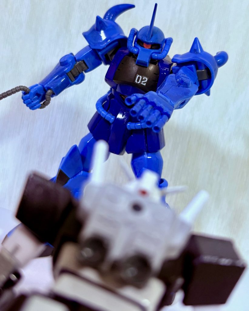 タカの代わりにプロトタイプガンダムに乗ったニャアンとマチュのジークアクスは宇宙用に改造されたリック・グフ(元ネタは絵本版ファーストガンダム)のMAVに苦戦する。パイロットは元ジオン兵だが一年戦争を生き延びただけあり、かなりの手練れである。なお、ユージのガンダムはクランバトルのしすぎで四十肩(隠喩)になったらしい。