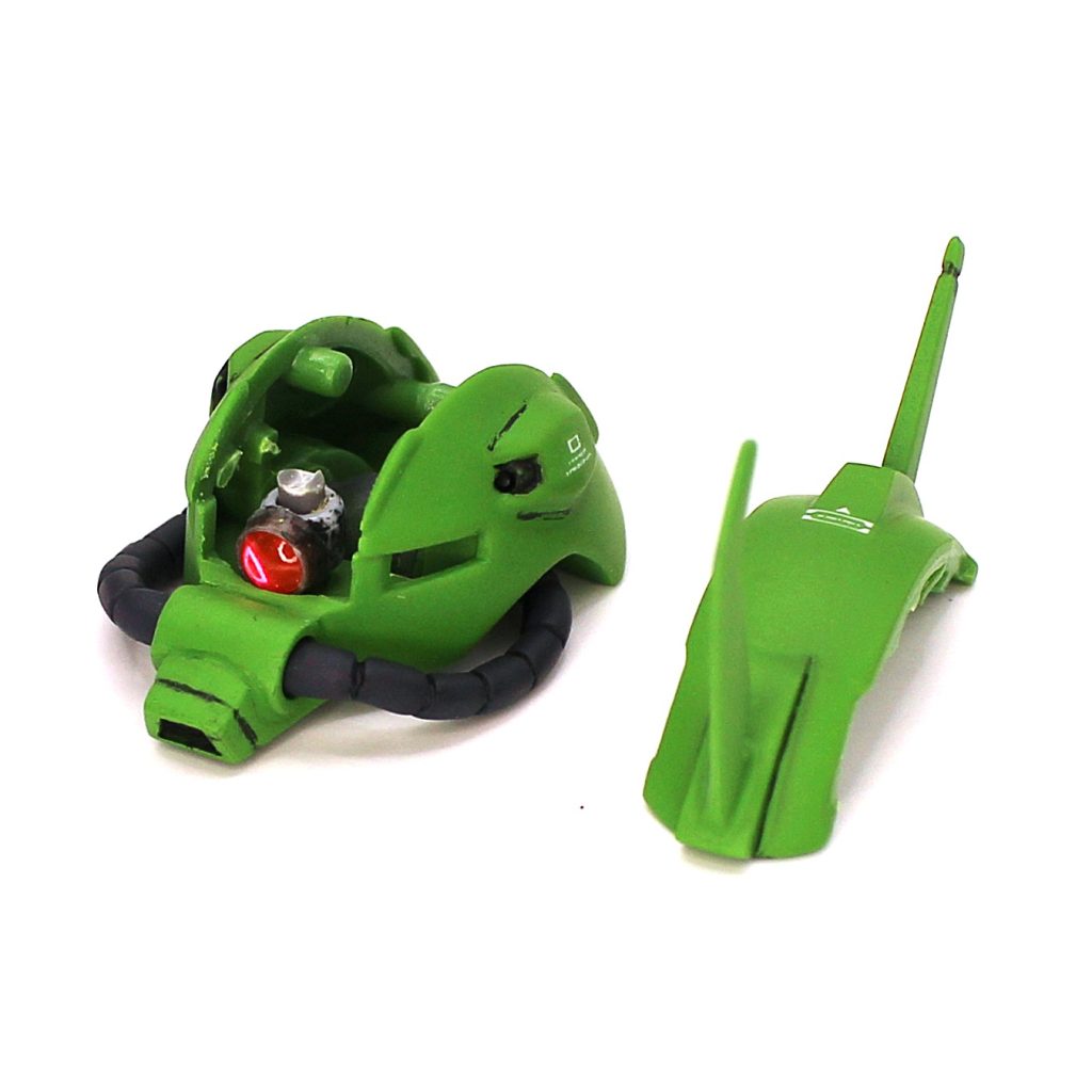 キットのモノアイシールを貼るカマボコ型のパーツを使わず、それが入るスペースの底面に穴を空け、そこに軸を挿します。モノアイはビルダーズパーツのMSパイプの1駒の側面にWAVEのU・バーニア フラット2.5mmを接着し、奥にメタリックシールを貼ってその上からクリアピンクのレンズパーツを嵌めました。このモノアイを頭部内に立てた軸に通せば完了です。