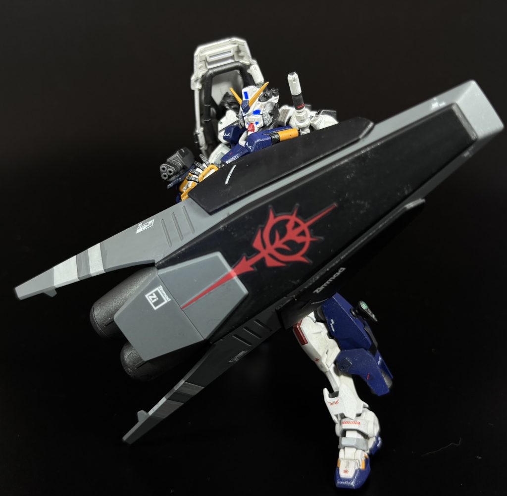 [チョバム・シールド・ブースター]基本装備ではないが、特殊装備として本機とともに試験運用されている超大型のシールド。大気圏再突入機能を持つシャトルの底面を転用した積層装甲を主体とした超大型のシールドで、数発であれば、戦艦級のビーム砲の直撃にも耐えるとされる。