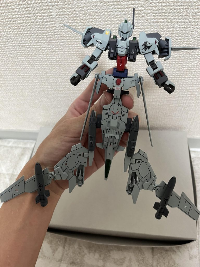 胸部を90度起こし、コクピットパーツを反転させ、顔を展開腕を展開し、腰部サイドアーマーのウイングを下ろす。背部のスラスターも展開