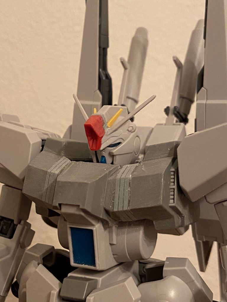 加工中の頭部と胸部。頭部はハイメガキャノンを移植し、目を新造するとともにクマが狭くなるよう配置。加えてマスクごと上方に位置をずらしました。この後顎も大型化し、ZZ的な雰囲気を持たせました。胸部は左右3mmずつ、胸部前方天面を伸ばす感じの拡幅なので、わずかに肩の位置が上がっています。さらに首の付き位置を下方に変えているのでかなり猪首な感じです。ここに胸部装甲を合わせることで、顔が埋もれて着膨れした雰囲気を出したかったのです。